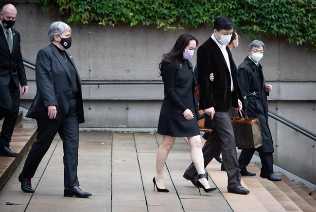 Meng Wanzhou, centre, chief financial officer of Huawei, leaves B.C. Supreme Court with her husband Liu Xiaozong, during a break from a hearing in Vancouver, on Wednesday, December 9, 2020. THE CANADIAN PRESS/Darryl Dyck