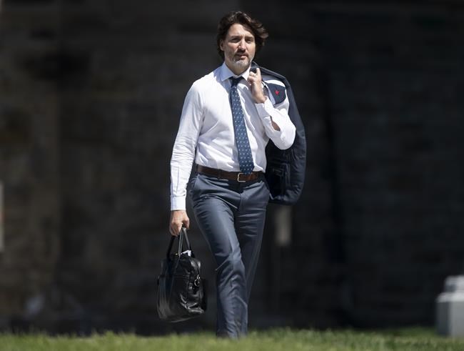 Prime Minister Justin Trudeau walks between buildings in the Parliamentary precinct in Ottawa on Friday May 28, 2021. The United Kingdom's prime minister says that Prime Minister Justin Trudeau will attend the G7 Leaders' Summit in person next month. THE CANADIAN PRESS/Adrian Wyld
