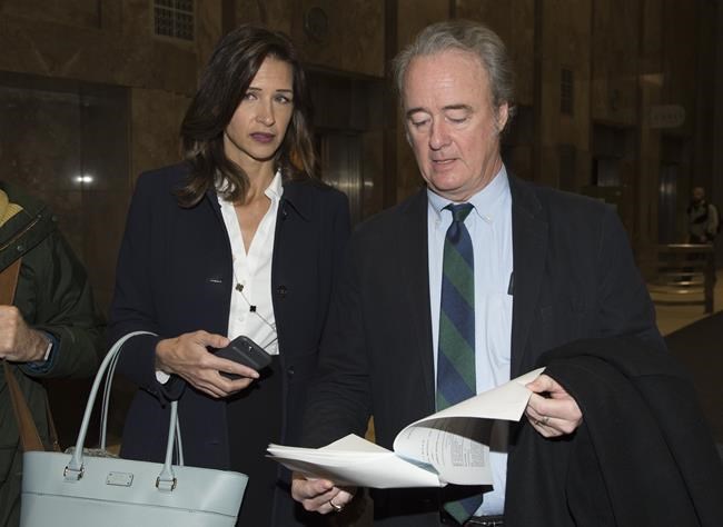 Lisa and Warren Kinsella read a copy of a verdict in a court case, in Toronto, Thursday, Jan. 24, 2019. Warren Kinsella, a prominent political commentator, is asking a court to dismiss a defamation lawsuit from a former member of Parliament who is now leader of a fringe federal political party. THE CANADIAN PRESS/Frank Gunn