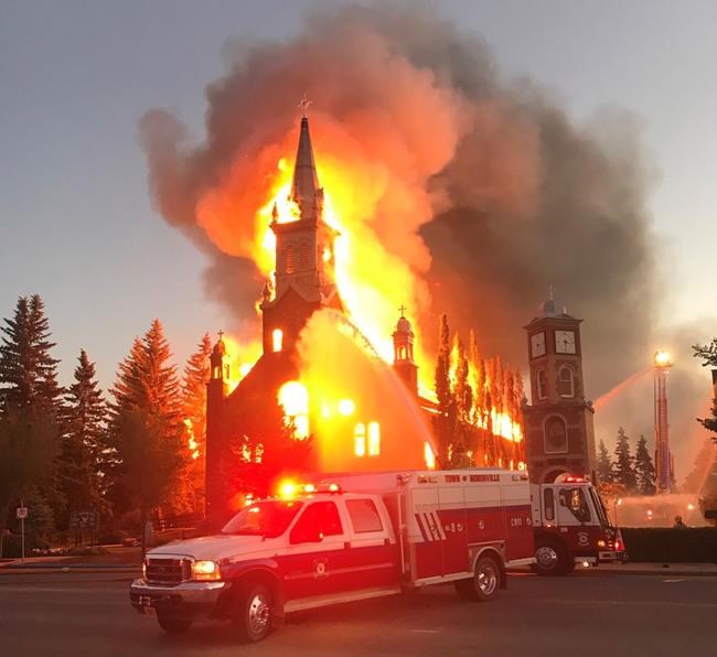 A fire burns a Catholic Church as shown in this handout image provided by Tracy Dalzell-Heise in Morinville, Alta., on Wednesday, June 30, 2021. RCMP say in a release that officers were called to the blaze at St. John Baptiste Parish in Morinville, about 40 kilometres north of Edmonton, just after 3 a.m. They are calling the fire suspicious. THE CANADIAN PRESS/HO-Communications and Legislative Services-Tracy Dalzell-Heise*MANDATORY CREDIT*
