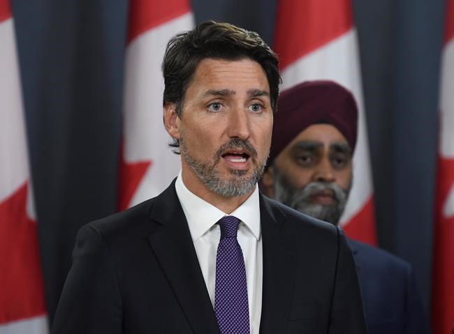 Prime Minister Justin Trudeau holds a news conference updating the Iran plane crash in Ottawa on Thursday, Jan. 9, 2020, as Defence Minister Harjit Sajjan looks on. THE CANADIAN PRESS/Adrian Wyld