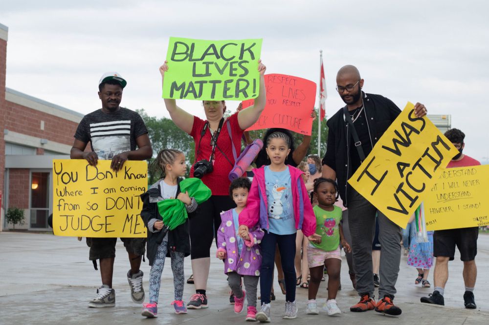 Nicole Buffie
Allen Jaber (right) and his family display homemade signs calling for racial justice and equality while they march down Main St. during the Black Lives Matter protest.