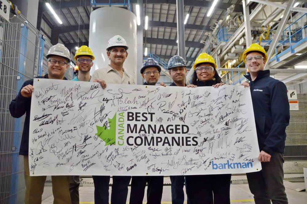 DAVE BAXTER | THE CARILLON
Barkman general manager Brian Pries, at left, and a number of Barkman employees hold up a banner signifying the company’s status as one of the Canada’s Best Managed Companies for 2018.
