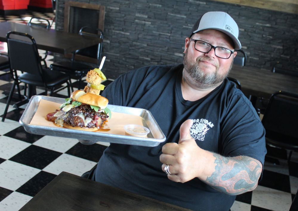 JORDAN ROSS | THE CARILLON
Bigg Smoak owner Rob Turner displays his restaurant’s entry for Steinbach Burger Days. The Bigg Smoak BBQ Burger features three Waygu beef patties, three types of cheese, and chicken-fried brisket cubes.