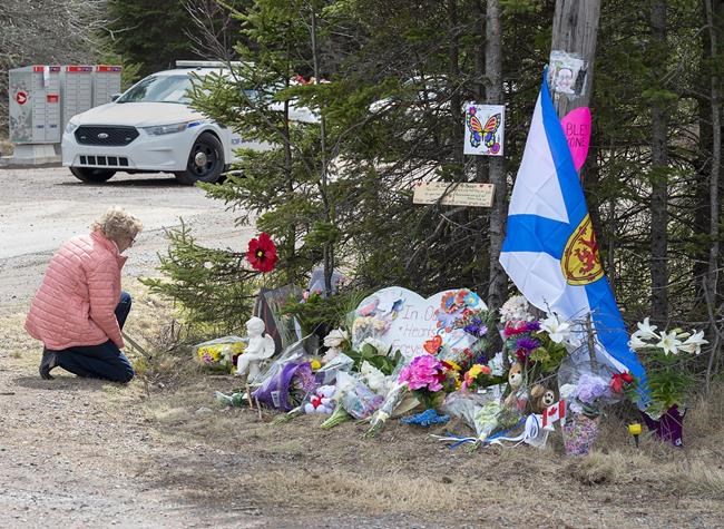 Family members of people killed during the Nova Scotia mass shooting are seeking to launch a class action against the RCMP and the province, arguing police failed to provide adequate protection and information to the public during the attacks. A woman pays her repects at a roadblock in Portapique, N.S. on Wednesday, April 22, 2020. THE CANADIAN PRESS/Andrew Vaughan