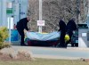 Workers with the medical examiner's office remove a body from a gas bar in Enfield, N.S. on April 19, 2020. Three Liberal MPs from Nova Scotia have come forward to challenge a decision by Ottawa and the province to conduct a joint review into the mass shootings in April that claimed 22 lives. Darren Fisher, the MP for Dartmouth-Cole Harbour, issued a statement today saying the gravity of the tragedy demands an independent public inquiry, which would have more authority than a joint review. THE CANADIAN PRESS/Andrew Vaughan