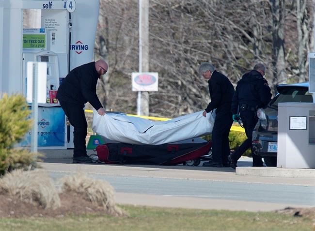 Workers with the medical examiner's office remove a body from a gas bar in Enfield, N.S. on April 19, 2020. Three Liberal MPs from Nova Scotia have come forward to challenge a decision by Ottawa and the province to conduct a joint review into the mass shootings in April that claimed 22 lives. Darren Fisher, the MP for Dartmouth-Cole Harbour, issued a statement today saying the gravity of the tragedy demands an independent public inquiry, which would have more authority than a joint review. THE CANADIAN PRESS/Andrew Vaughan