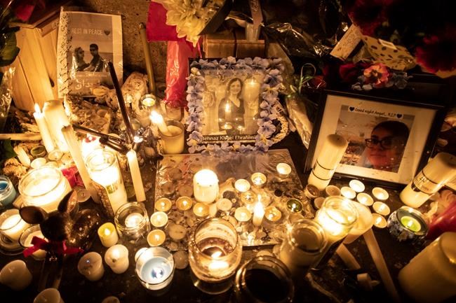 Photographs are left among candles at a memorial during a vigil in Toronto on Thursday, January 9, 2020, to remember the victims of the Iranian air crash. THE CANADIAN PRESS/Chris Young