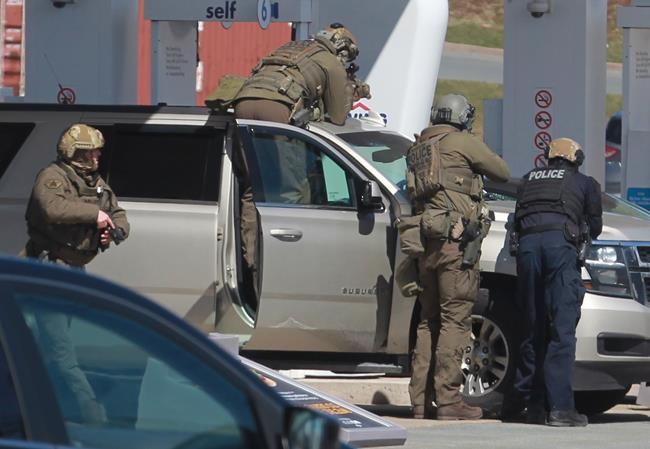 RCMP officers prepare to take a person into custody at a gas station in Enfield, N.S. on Sunday April 19, 2020. A suspect in an active shooter investigation is in custody in Nova Scotia, with police saying several people were harmed before a man wearing police clothing was arrested. Gabriel Wortman was arrested by the RCMP at the Irving Big Stop in Enfield, N.S., about 35 km from downtown Halifax. THE CANADIAN PRESS/Tim Krochak