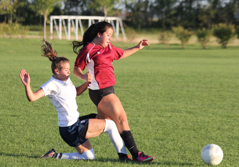 IAN FROESE | THE CARILLON
Hanover Haze's Sabine Neufeld, wearing white, reaches for the ball against Ste Anne Superbad's Amanda Hudrick in a game on Monday.