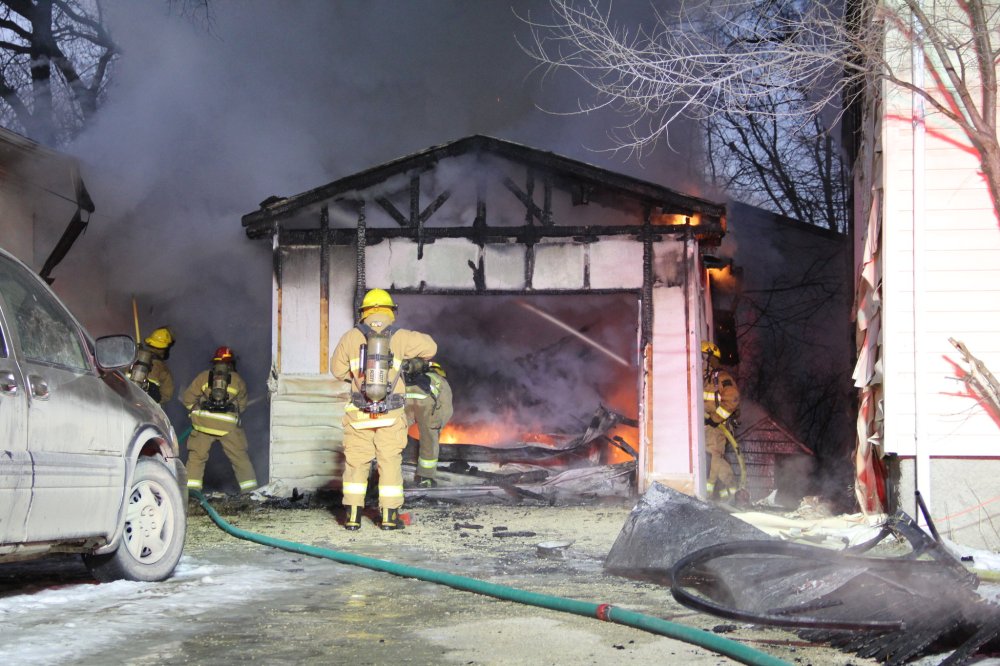 IAN FROESE | THE CARILLON
Firefighters work to extinguish a blaze that originated in a garage late Monday afternoon on Reimer Avenue in Steinbach