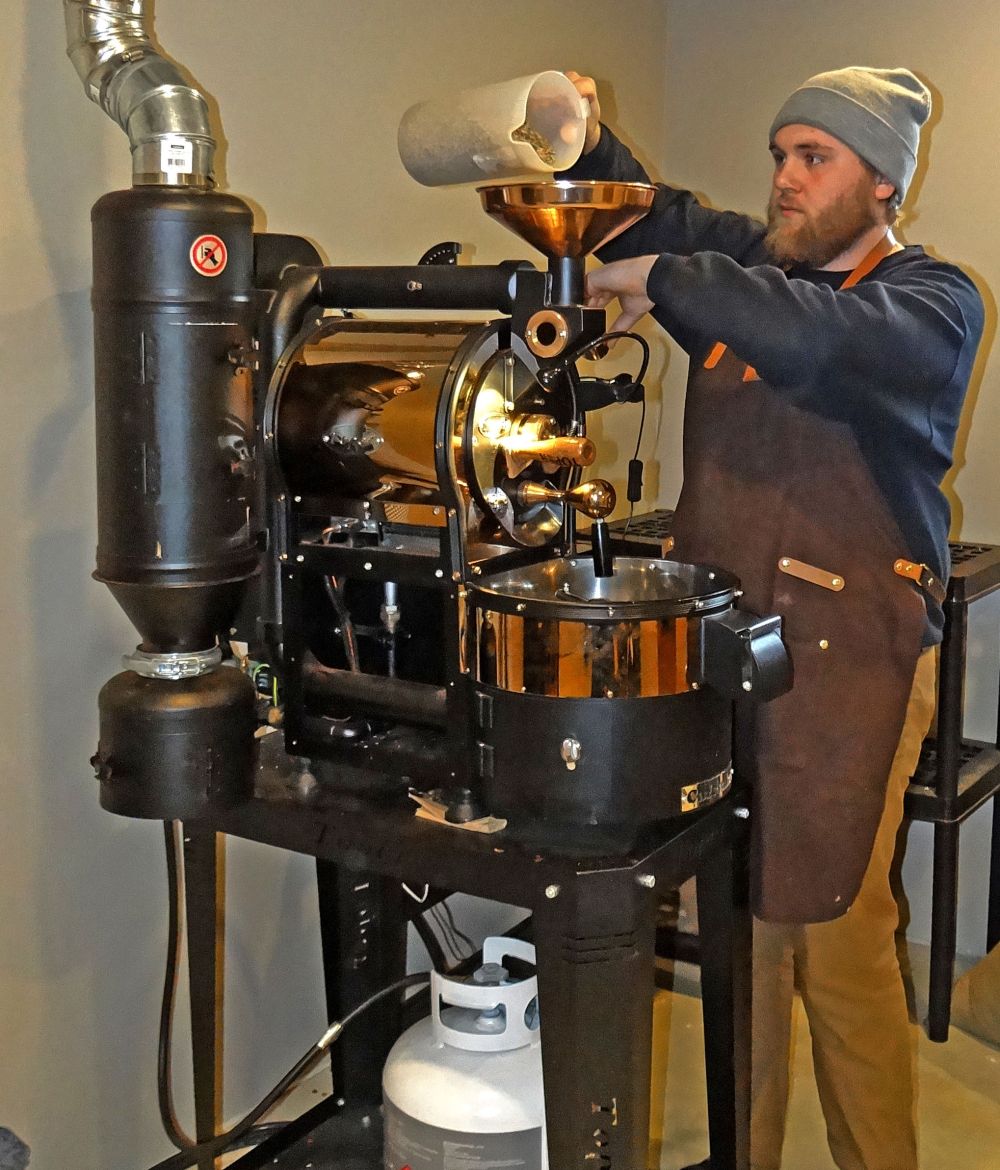 WES KEATING | THE CARILLON
Another batch of coffee is heading for the market as Josh Lepp pours a kilogram of beans into the roaster.