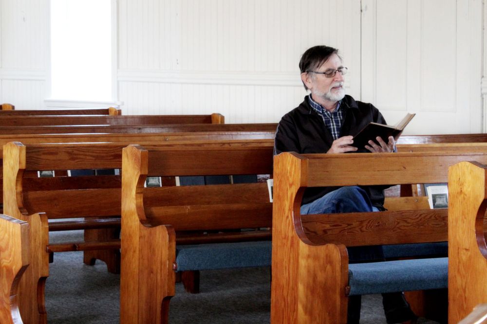 KAITLYN KOZARCHUK | THE CARILLON
Ernest Braun flips through one of the old hymnals used by Mennonite immigrants at the Chortitz Heritage Church in Randolph.