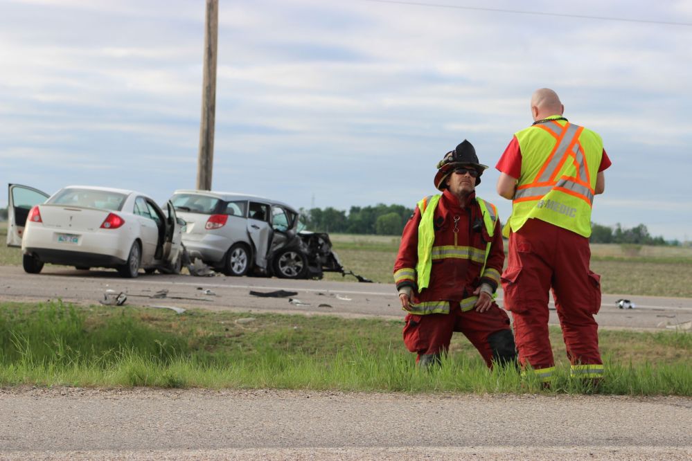 GRANT BURR | THE CARILLON
Members of the Kleefeld fire department speak on the scene of a two-vehicle collision at the intersection of Highway 52 and Provincial Road 216 on Thursday night.