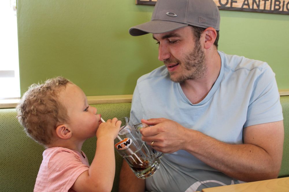 GREG VANDERMEULEN / THE CARILLON
Three-year-old Nikolaj van der Breggen enjoys the final drops of his drink thanks to his dad Tom during the celebration.