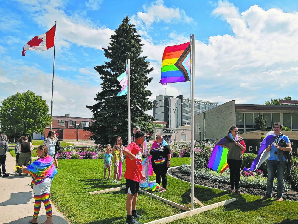 PHOTO BY KEN MACDONALD
March participants set up their own flag poles to fly Pride flags outside Steinbach City Hall after council decided against allowing the flags to be flown on city poles.