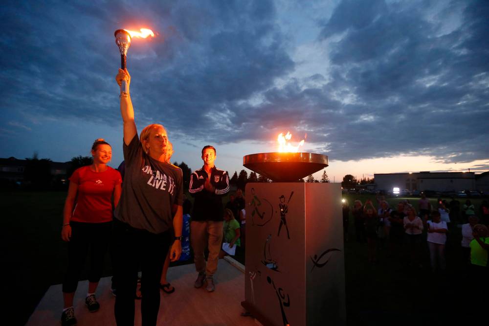 Michelle Sawatzky-Koop lights the cauldron at the opening ceremonies of the Manitoba Games in Steinbach, Sunday, August 7, 2016. (John Woods Winnipeg Free Press)