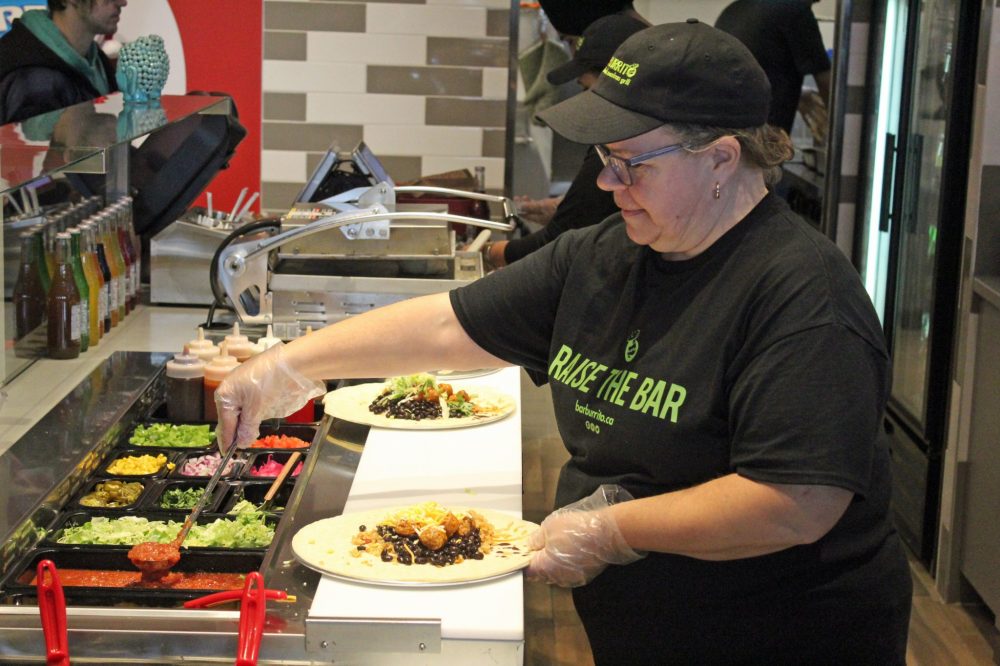 JORDAN ROSS THE CARILLON
A BarBurrito employee whips up a burrito following Monday’s ribbon cutting ceremony.