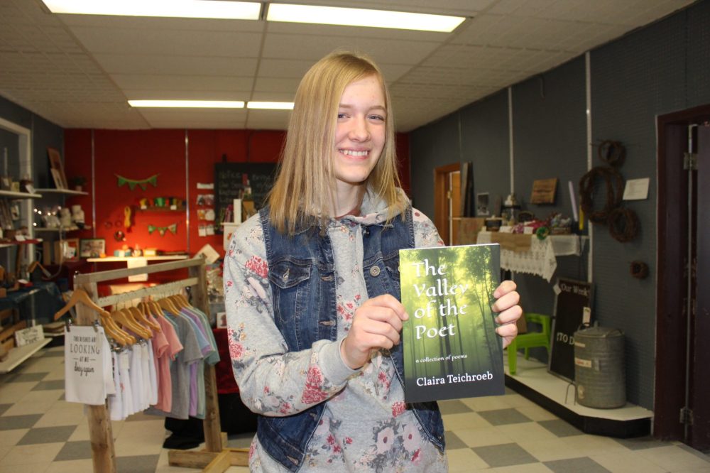 JORDAN ROSS THE CARILLON
Claira Teichroeb displays a copy of her debut poetry collection, The Valley of the Poet, at Artisan Hall inside Reimer Concrete and Building Supplies.