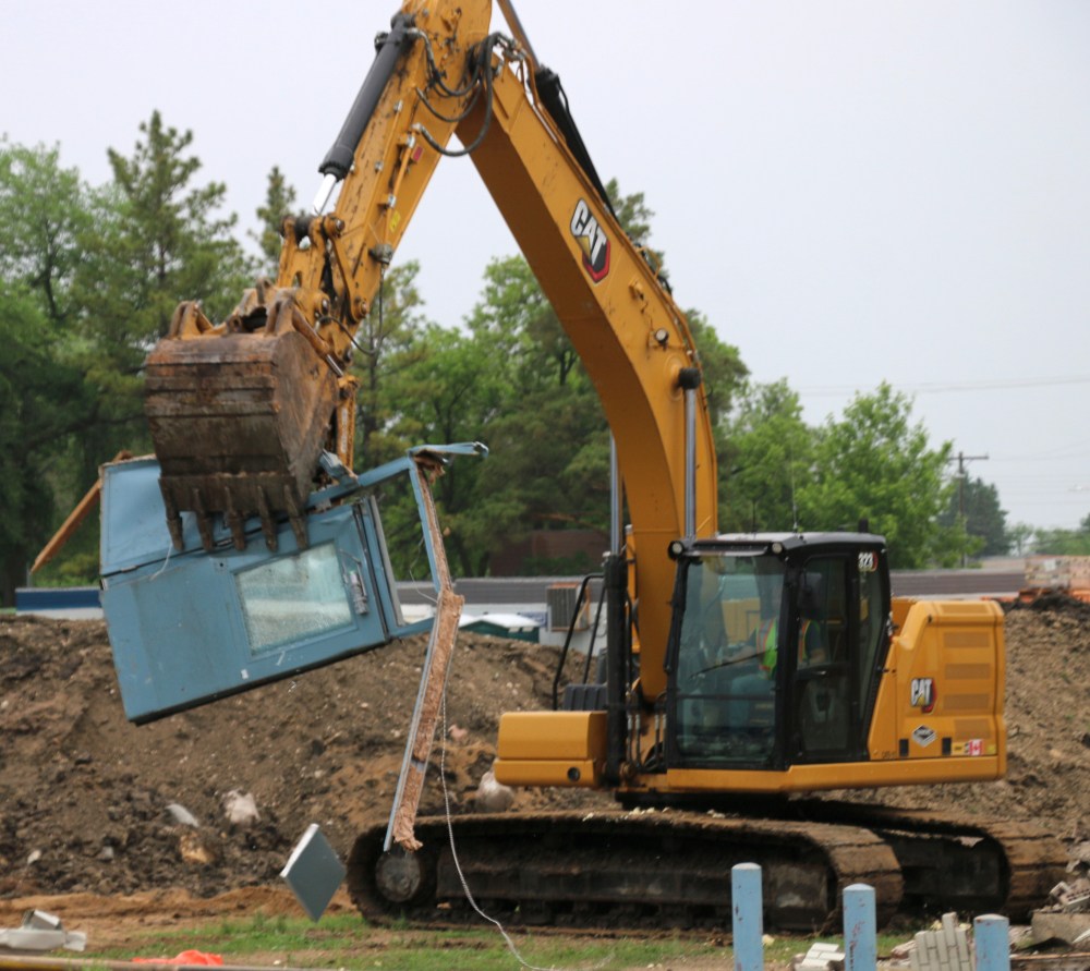 One of the backhoe operators pulls one of the arena's front doors to the side. (Cassidy Dankochik The Carillon)