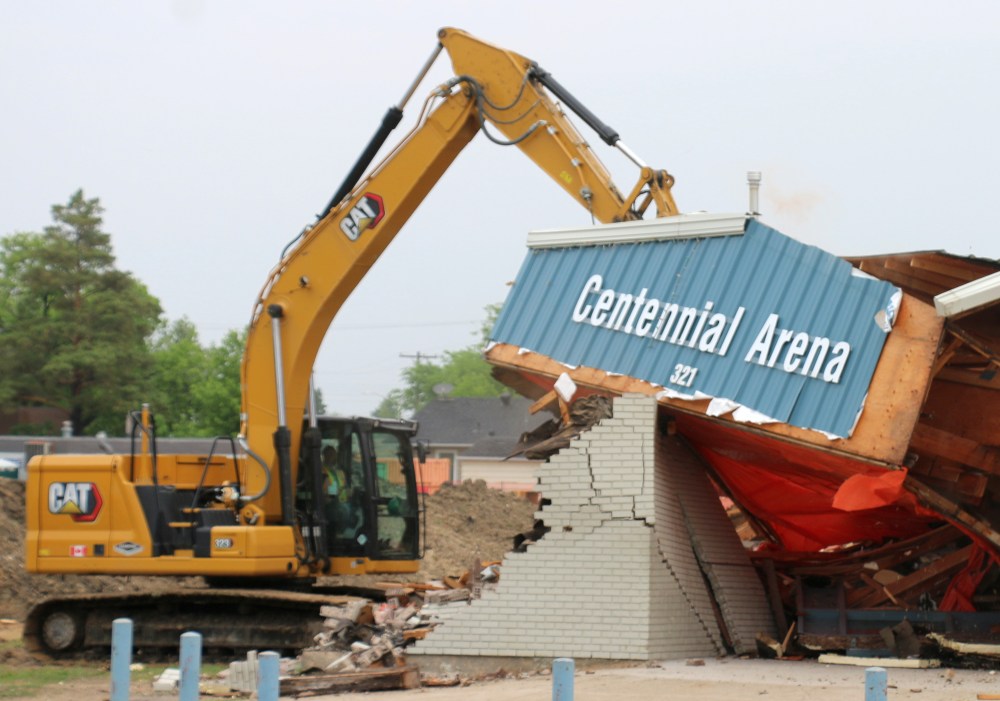 The sign marking the front of the Centennial Arena comes tumbling down during the building's demolition June 7. (Cassidy Dankochik The Carillon)