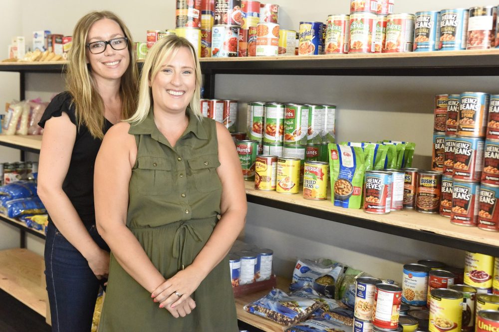 SVJETLANA MLINAREVIC the Carillon
Niverville Helping Hands board chair Larissa Sandulak (left) and secretary Alexandra Rezansoff stand next to pantry items that are on hand for people using the food bank to pick up at their new location. At the former location, the food bank had to pack hampers whereas the new model gives more empowerment to clients.