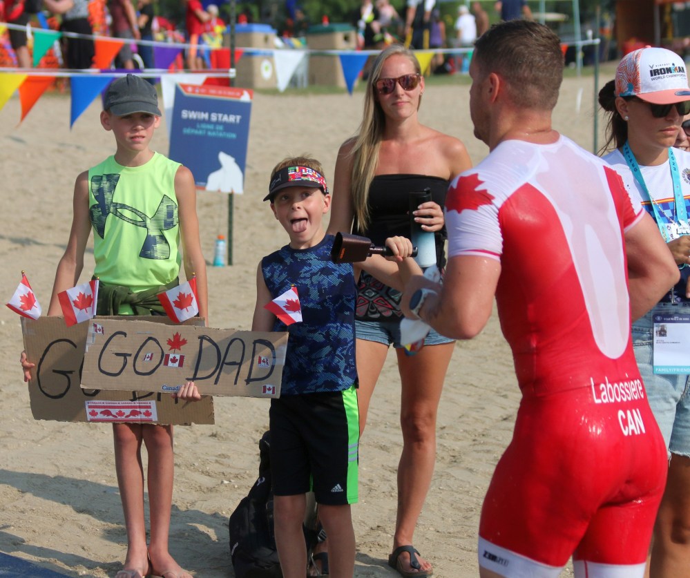 Winnipeg Fire and Paramedic Services member Patrick Labossiere gets support from his family as he transitions from the swimming section of the World Police and Fire Games triathlon to the bike ride. Labossiere didn't just compete in the event, he also helped organize it. (Cassidy Dankochik The Carillon)