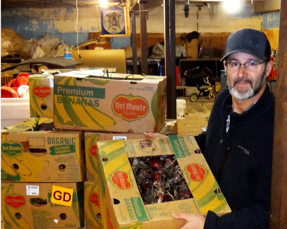 WES KEATING THE CARILLON
Ian Kleinsasser shows a stack of boxes of potatoes packed and ready to be sent to local food banks.