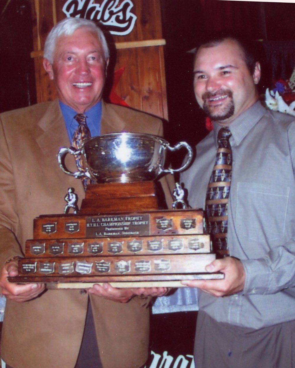 Legendary Montreal Canadiens captain Jean Beliveau presents the Hanover Tache Hockey League trophy to La Broquerie Habs Captain Louis Cote at a gala celebrating 50 years of LaBroquerie Habs hockey.