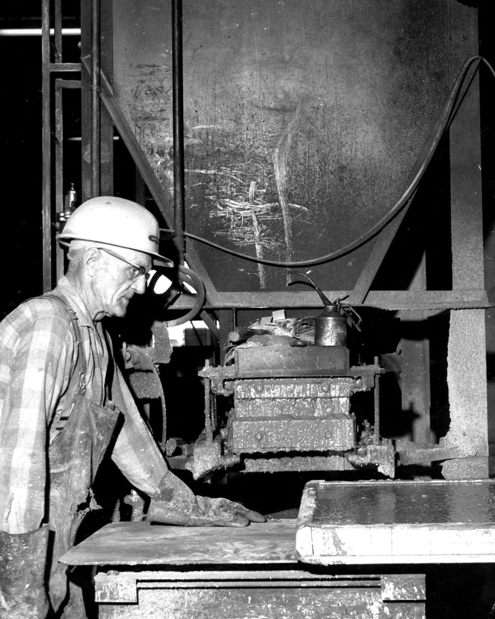 CARILLON ARCHIVES
Gottlieb Borkowsky removes a finished block from the huge hydraulic press that makes super hard concrete blocks at Barkman Concrete.
