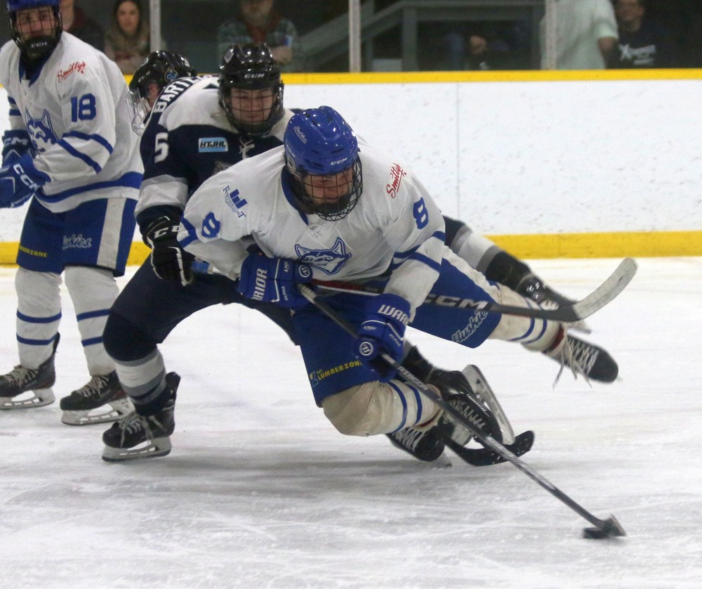 Keyan Grimard fights to get a shot off as he is knocked down in game two of the HTJHL finals March 9. (Cassidy Dankochik The Carillon)