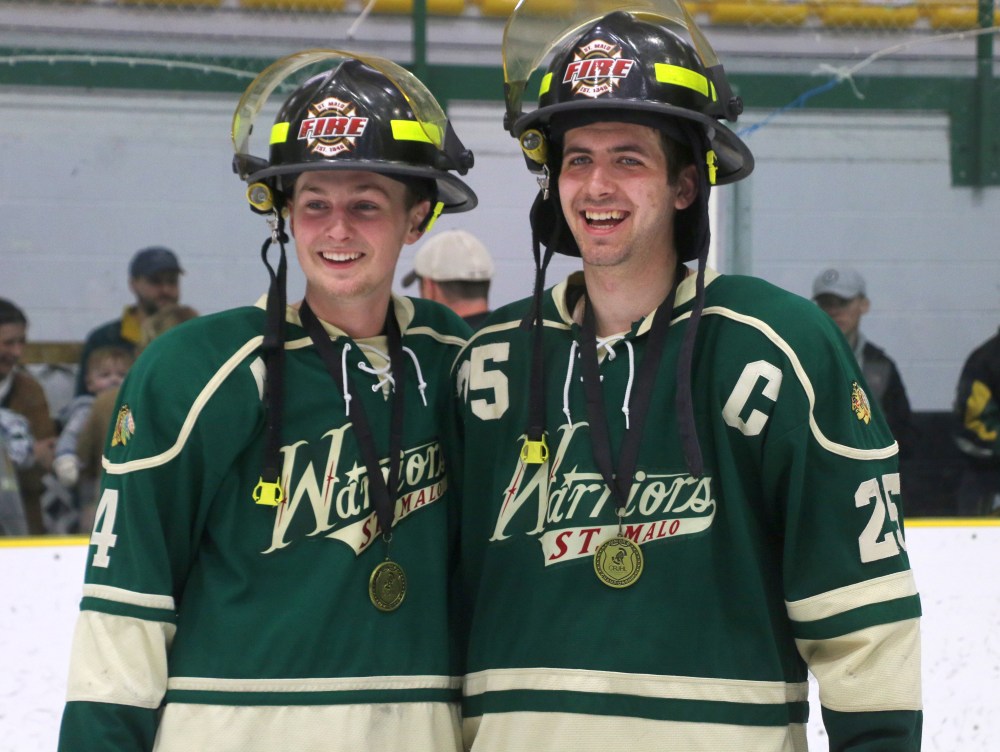 Colton Magne and Thomas Maynard sport their St Malo Fire Department helmets after winning the Capital Region Junior Hockey League Finals April 5. (Cassidy Dankochik The Carillon)
