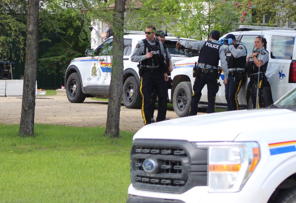 CHRIS GAREAU THE CARILLON
Steinbach RCMP gather at the McKenzie Avenue home where they shot a black bear in the backyard after unsuccessfully trying to escort it out of town on Victoria Day.