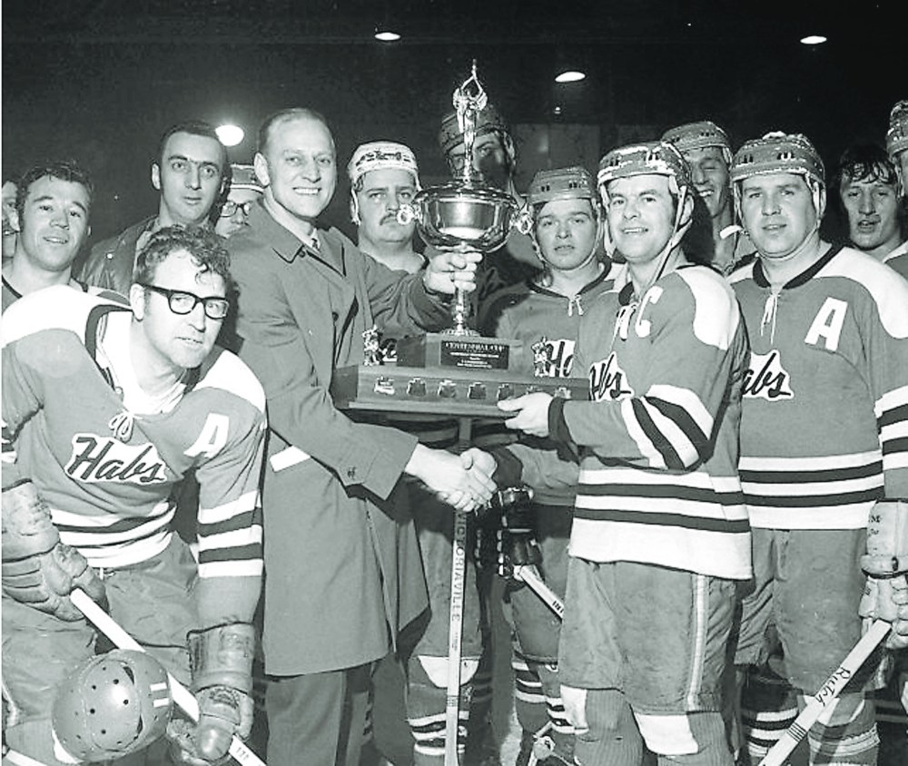 MEHL president Wally Rempel presents the Centennial Cup to the La Broquerie Habs as winners of the league championship two years in a row.