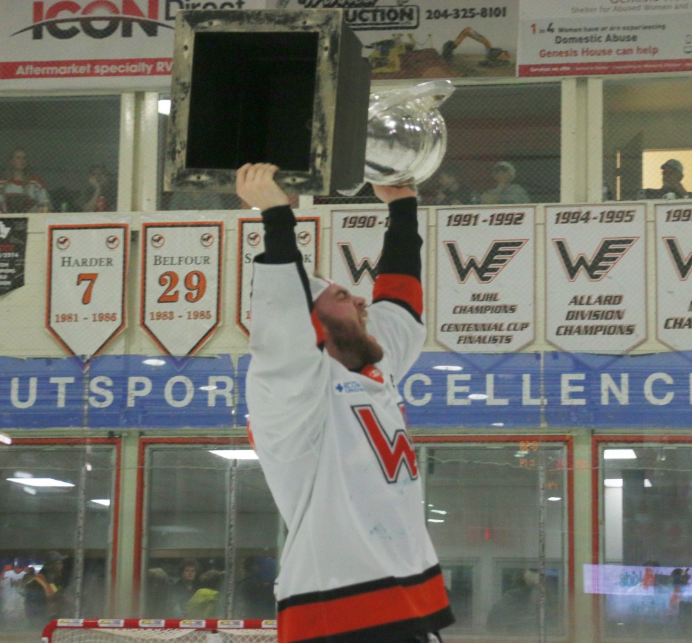 Mike Svenson yells in celebration while hoisting the Turnbull Cup above his head after helping Winkler to their first provincial championship since 1998. (Cassidy Dankochik The Carillon)