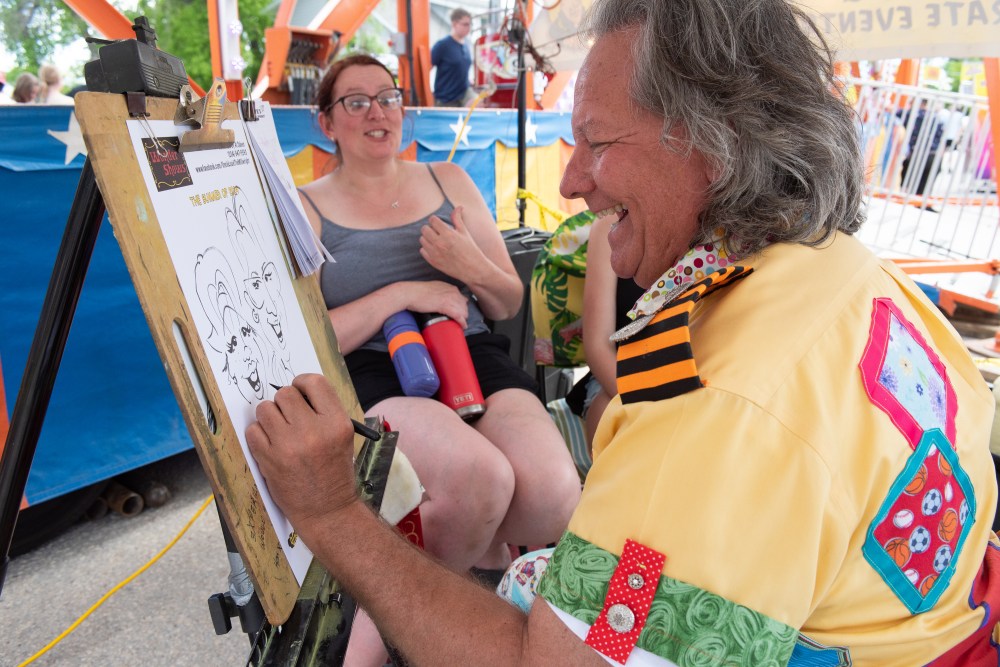 SVJETLANA MLINAREVIC THE CARILLON
Holly Olesen shares a funny story while characture artist Alan Sideen draws her portrait during the Niverville Fair on June 8, 2024.