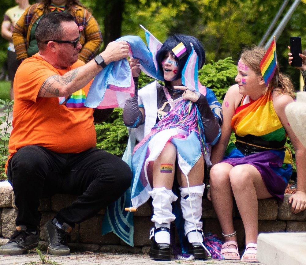 SVJETLANA MLINAREVIC THE CARILLON
NDP MLA Logan Oxenham drapes the transgender flag around the shoulders of Hayden Lessard while her friend Payton Lagasse looks on during Steinbach Pride on June 23, 2024, at K.R. Barkman Park. Oxenham is Canada's first transgender MLA to win a seat in the legislature. In early June, he introduced a bill commemorating transgender and two-spirit people, which passed.