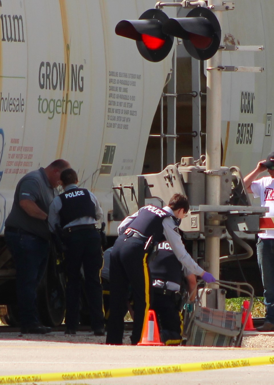 CHRIS GAREAU THE CARILLON
Steinbach RCMP remove a lawn chair from the train accident scene that claimed pedestrian Ida St. Vincent’s life during the Ste Jean Baptiste parade in La Broquerie June 23.