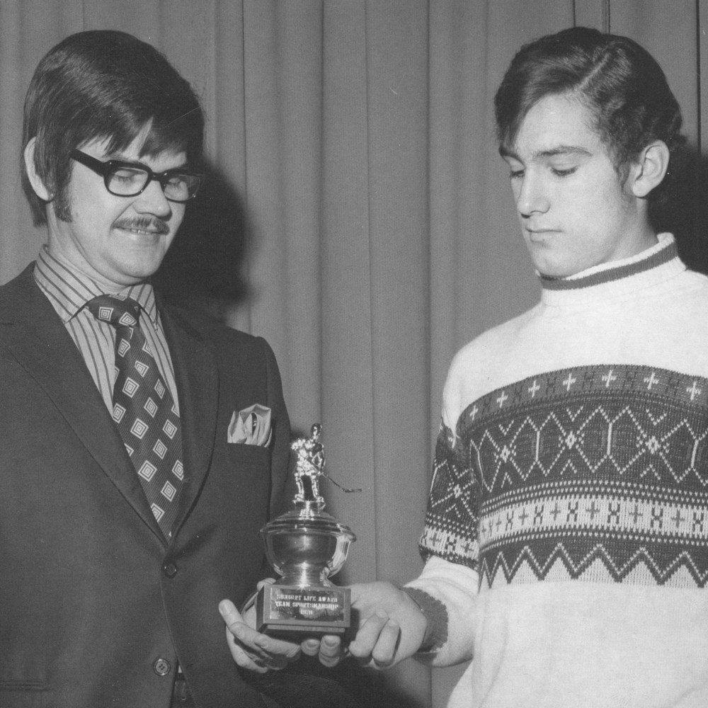 A decade before taking over the reins of Steinbach’s “Under 18” regional “AAA” team, Gil Penner enjoyed success coaching Steinbach high school hockey teams to back-to-back provincial titles. Admiring one of the many 1971 tournament trophies the high school team won are Coach Penner and SCI captain Ralph Krentz.