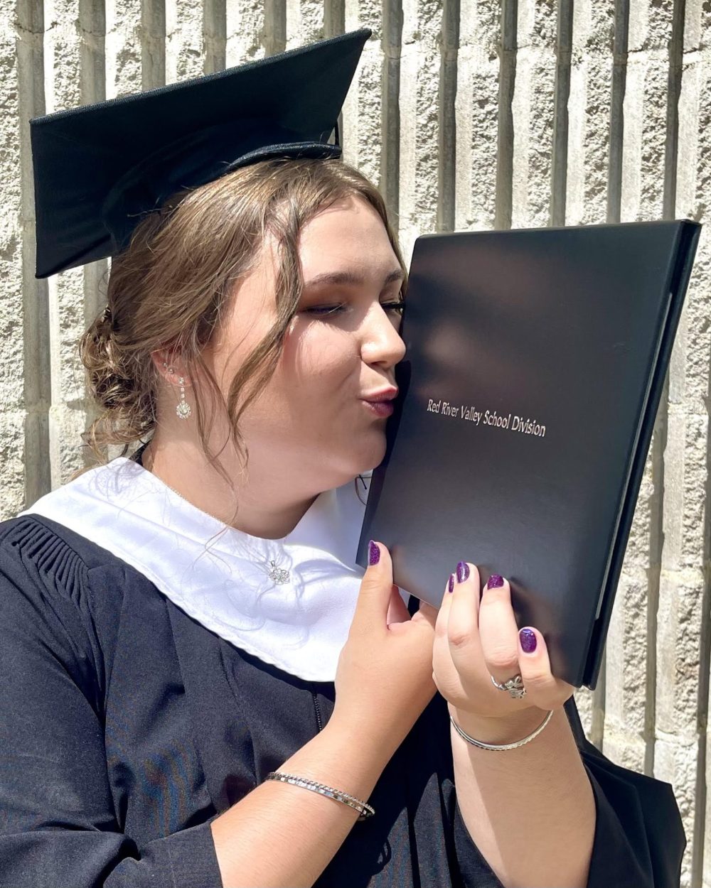 LORI PENNER THE CARILLON
Morris graduate Ginger Jorgenson kisses her diploma.