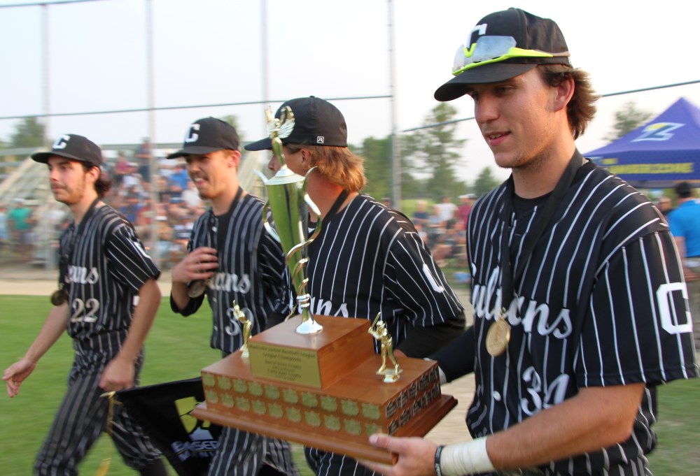 Carillon's four graduating players walk the trophy back to their teammates. (Alex Lambert The Carillon)