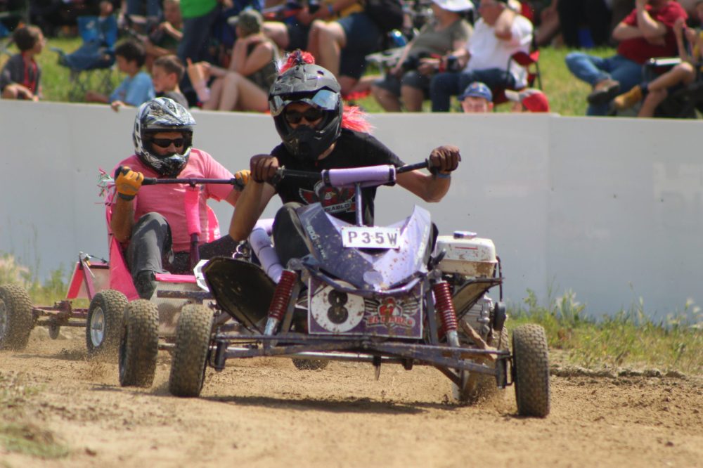 CHRIS GAREAU THE CARILLON
The driver for Spark Plug Cup winner and hometown team Moonshadow Hogs tries to overtake the driver for El Diablo during their 100-lap second heat in front of a large crowd on a hot day at the 15th St Labre 200 last Saturday.