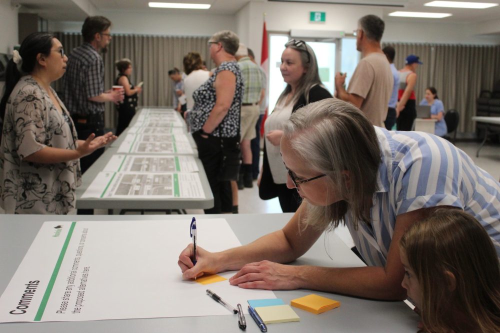 CHRIS GAREAU THE CARILLON
Helen Connelly writes her comment as daughter Gabrielle McDonald looks on at the open house in Ste Anne July 12. A public survey is still available at engagemb.ca/pth12.