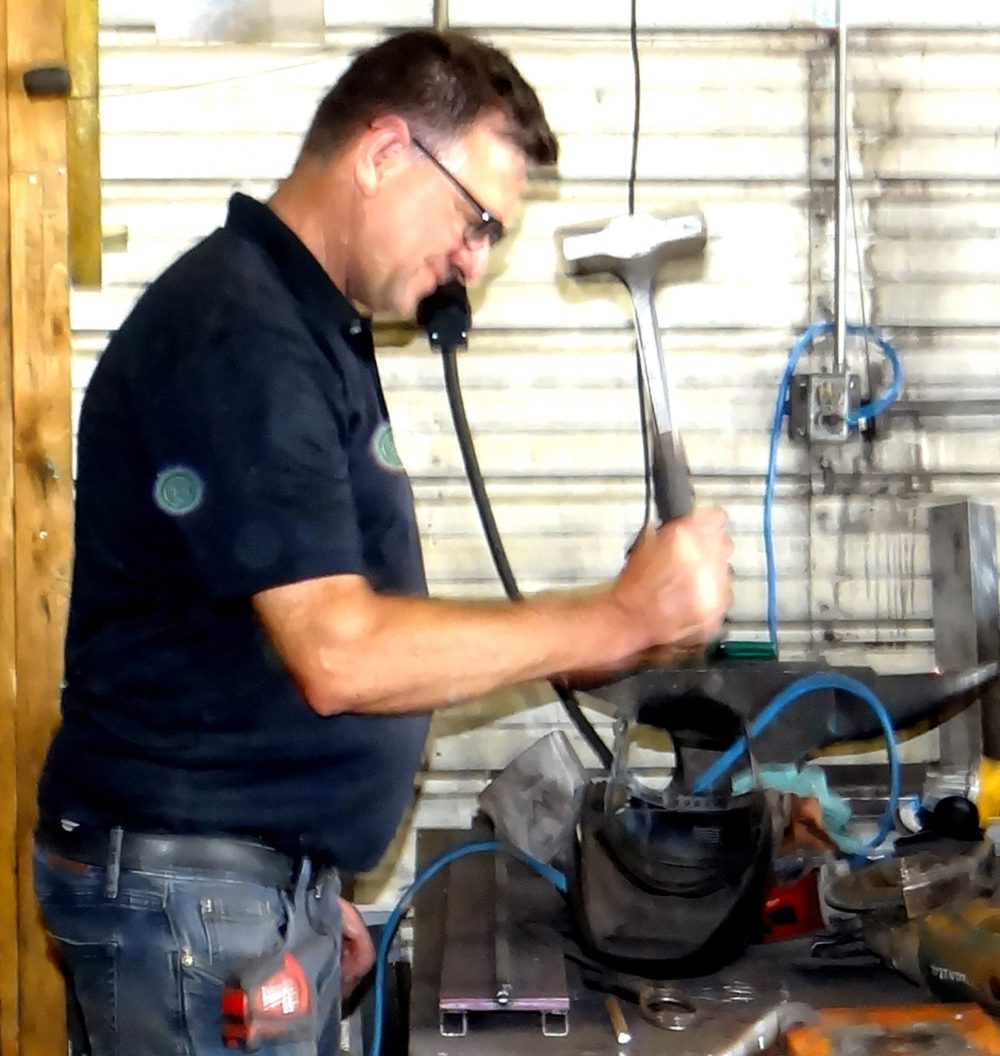 WES KEATING THE CARILLON
Long-time Heritage employee Wilhelm Friesen is set to demonstrate how he can punch a perfect hole in a piece of steel with one blow of his hammer. Removing a worn-out bearing was the task at hand in this case.