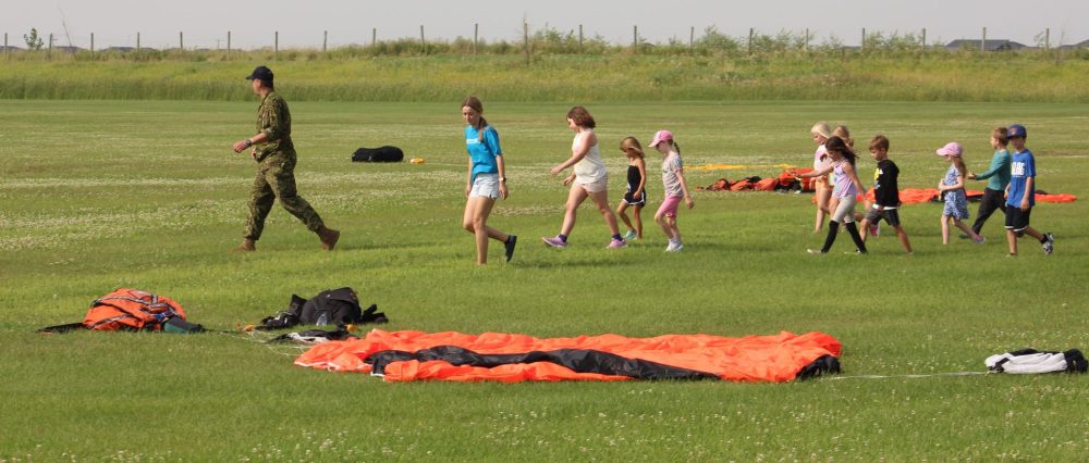 ALEX LAMBERT THE CARILLON
Cpl Black leads campers through the parachutes that were dropped minutes ago by Royal Canadian Air Force pilots.