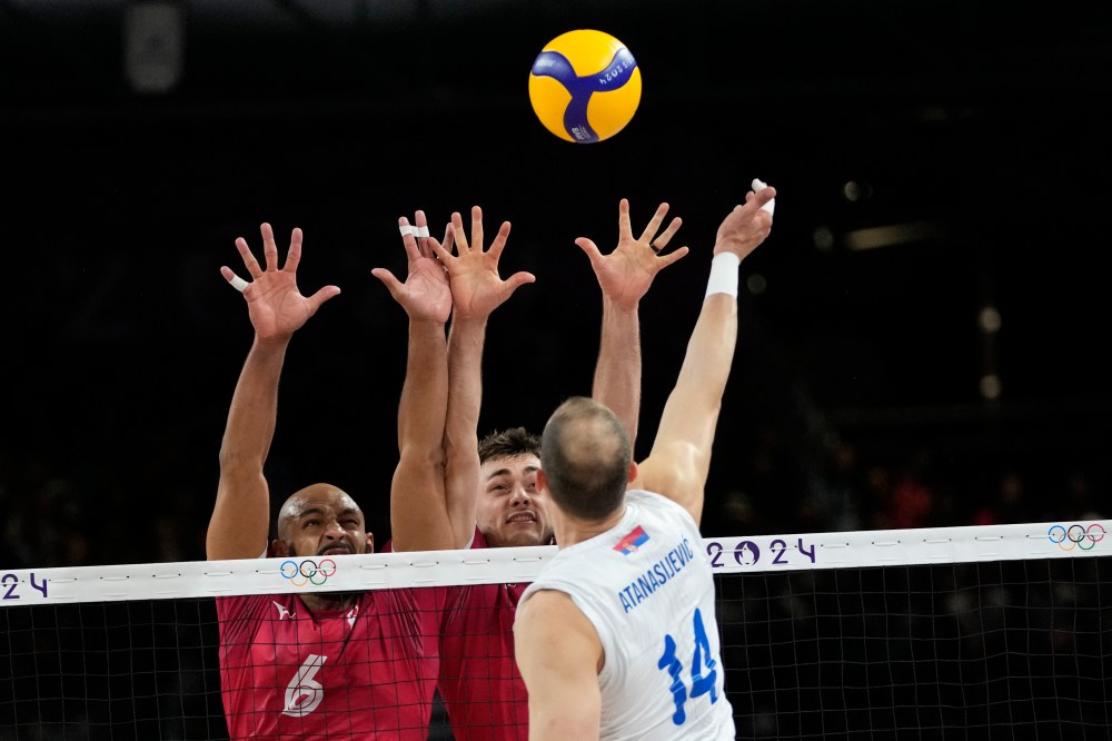 Danny Demyanenko left, and Eric Loeppky of Canada try to block a ball during the Group A men's volleyball match between Canada and Serbia at the 2024 Summer Olympics, Saturday, Aug. 3, 2024, in Paris, France. (AP Photo/Dolores Ochoa)
