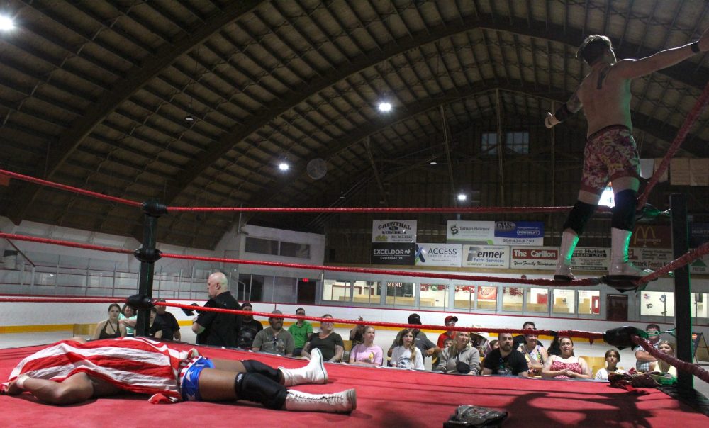 CHRIS GAREAU THE CARILLON
Canadian Wrestling’s Elite Central Canadian Champion Hotshot Danny Duggan may have defeated Bryce Bentley, but the champ still ended up on the mat and draped in his flag as Bentley gestures to the crowd after their match in Grunthal Aug. 3. The CWE was also in Roseau River First Nation Wednesday for a free event, and returns to the Southeast for its annual outdoor summer spectacular at Lilac Resort on Aug. 17 with a Battle Royal to crown the first ever Lilac Resort Champion. The Rumble To Remember Tour comes to La Broquerie Oct. 5 headlined by an Over The Top Rope Rumble main event.
