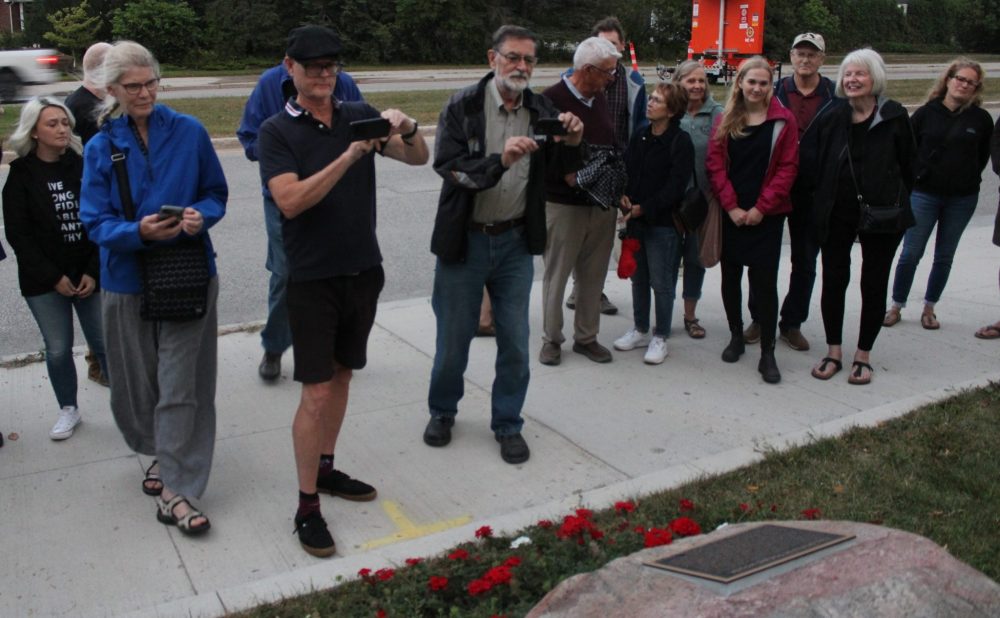 GREG VANDERMEULEN THE CARILLON
As darkness falls, Miriam Toews fans snap photos of the plaque.