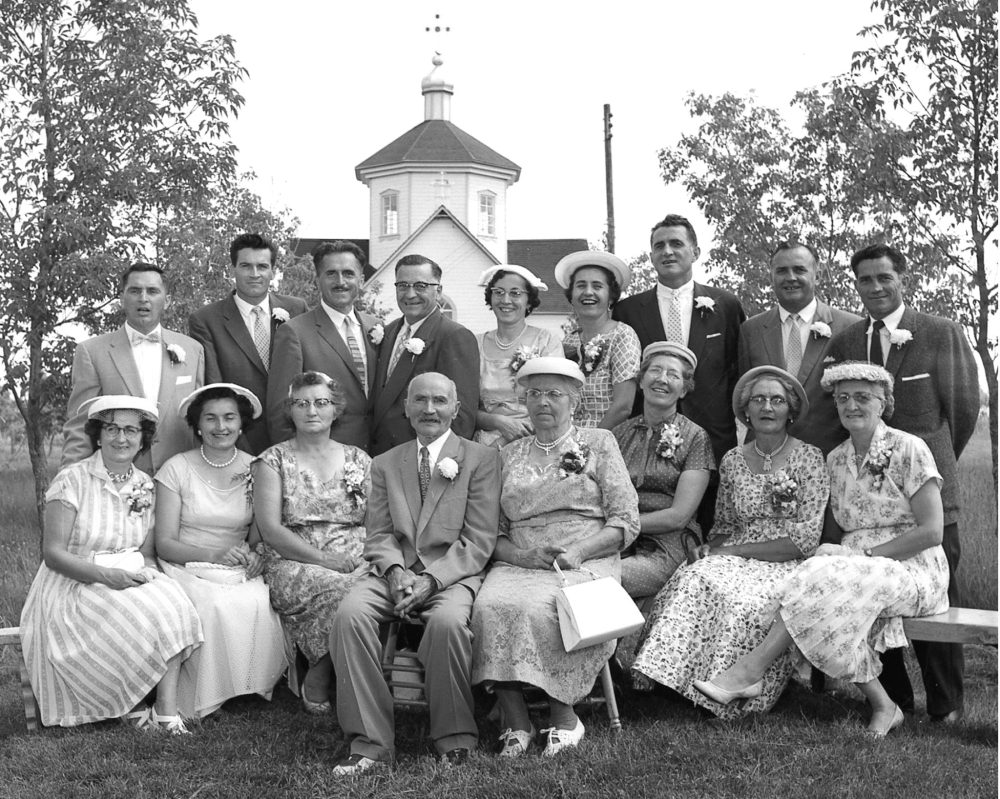 CARILLON ARCHIVES
With the Stuartburn Holy Trinity Ukrainian Catholic Church in the background, Theodosy and Anna Wachna pose for a family picture with all 15 of their children during celebrations of the couple’s 60th anniversary in 1957. They are; Back row: Ted, Elias, John, Boris, Claudia (Mrs A. Dolynchuk), Verna (Mrs Nestor Kostyniuk), Anthony, Walter and Casey. Front row: Olga (Mrs Michael Bednar), Eva (Mrs Michael Bially), Sophie (Mrs Peter Koch), Theodosy and Anna Wachna, Katherine (Mrs Dan Kostocky), Mary (Mrs John Kelner) and Lena (Mrs P. Moysiuk).