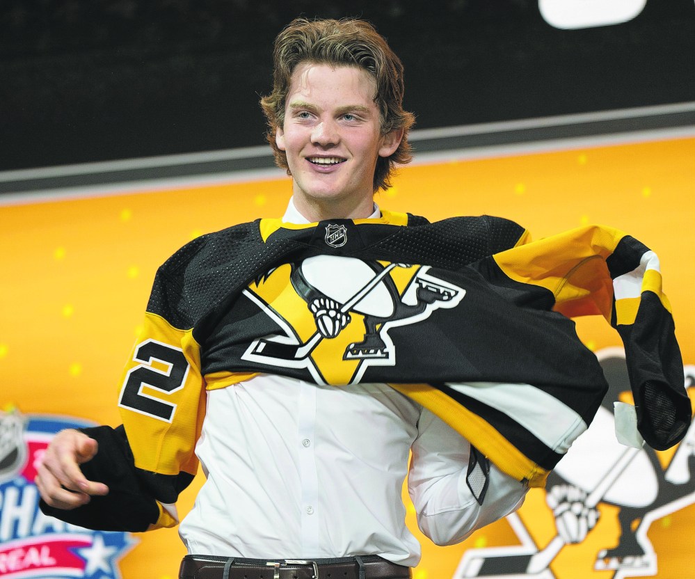Pittsburgh Penguins 21st pick Owen Pickering puts on his jersey during the first round of the 2022 NHL Draft Thursday, July 7, 2022 in Montreal. THE CANADIAN PRESS/Ryan Remiorz